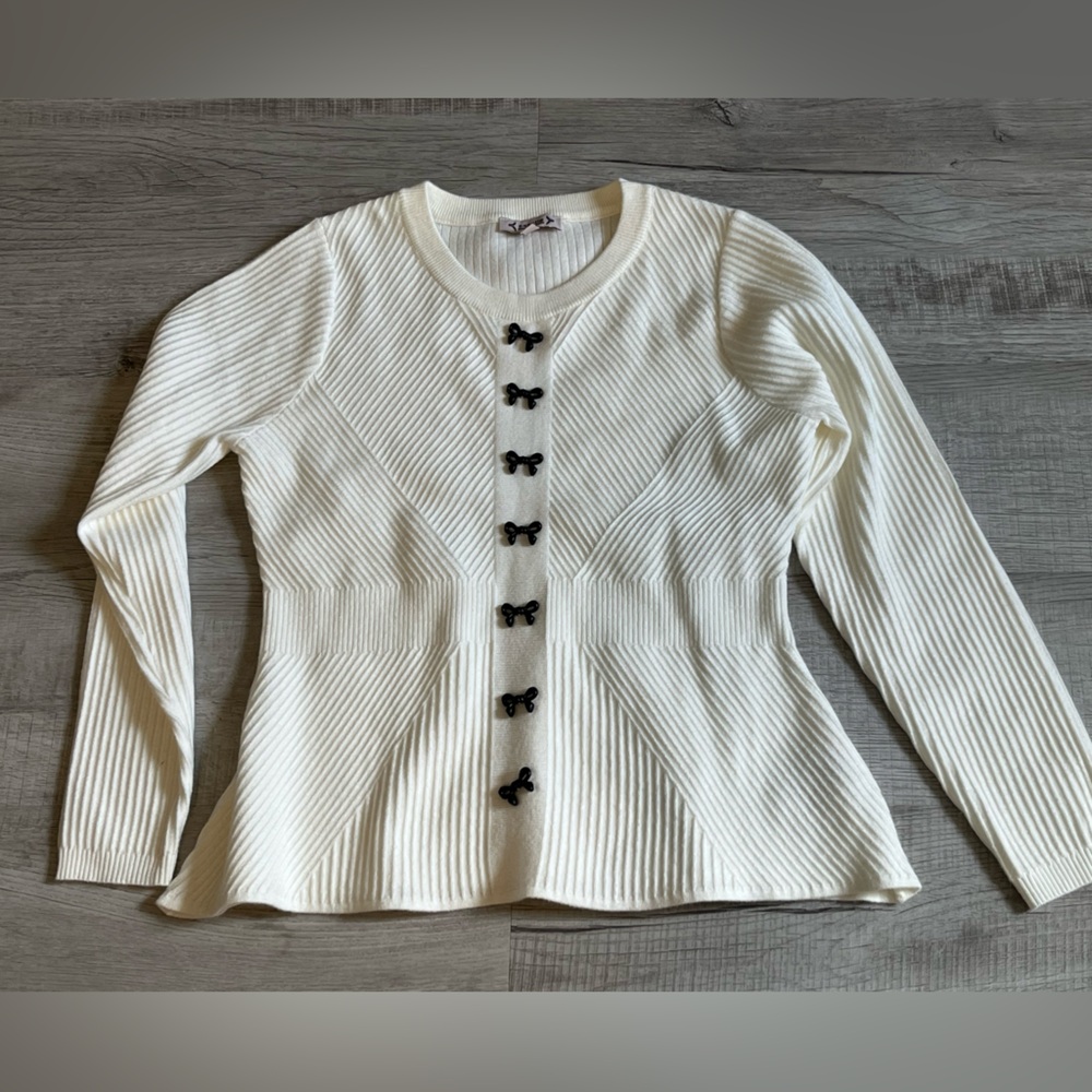 White sweater with bows in the middle like buttons but not